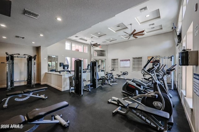 workout area featuring recessed lighting, visible vents, a ceiling fan, a textured ceiling, and coffered ceiling