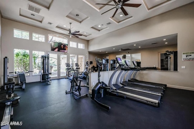 gym featuring baseboards, visible vents, coffered ceiling, a ceiling fan, and a high ceiling