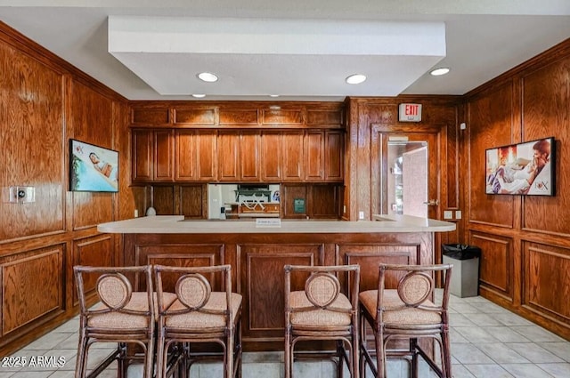 kitchen featuring wooden walls, light countertops, and light tile patterned flooring