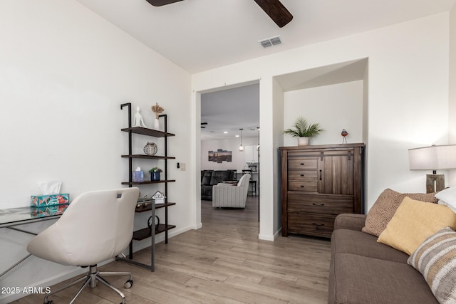 home office with a ceiling fan, light wood-type flooring, and baseboards