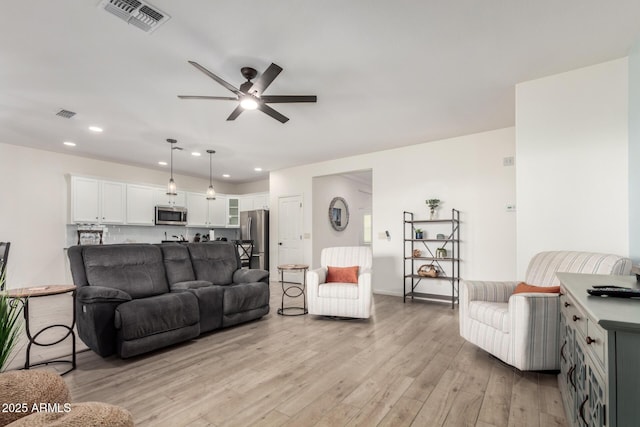 living room featuring ceiling fan, light wood-type flooring, and recessed lighting