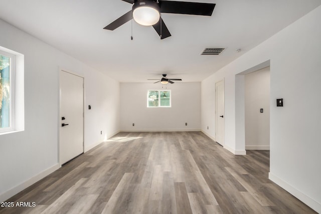 unfurnished room featuring visible vents, ceiling fan, light wood-style flooring, and baseboards