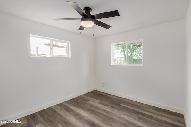 spare room featuring ceiling fan, baseboards, and dark wood-style flooring