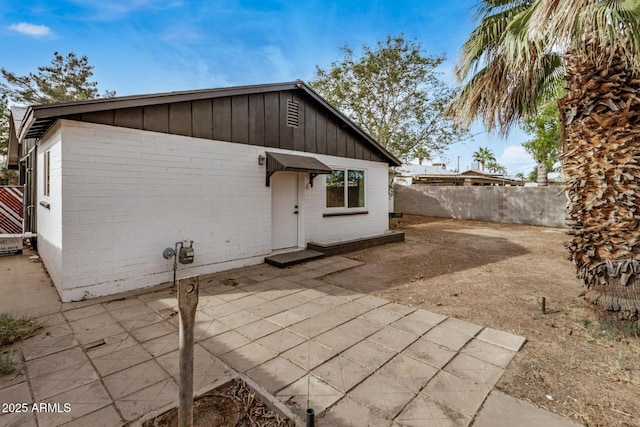 back of property with a patio, brick siding, and fence