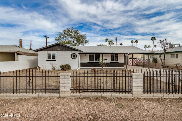 ranch-style house featuring a fenced front yard, an attached carport, driveway, and board and batten siding