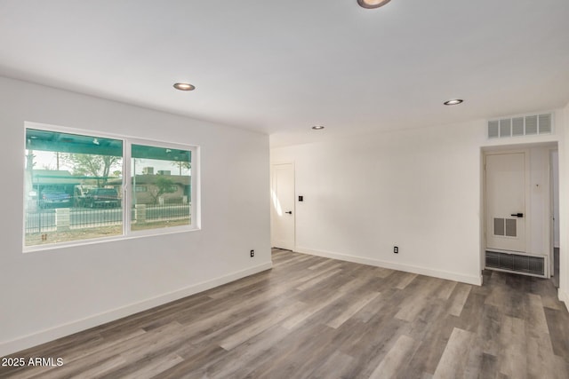 unfurnished room with baseboards, visible vents, wood finished floors, and recessed lighting