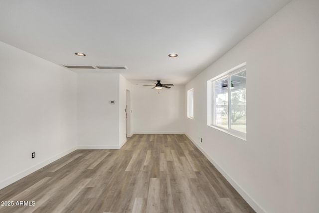 unfurnished room featuring recessed lighting, wood finished floors, a ceiling fan, and baseboards