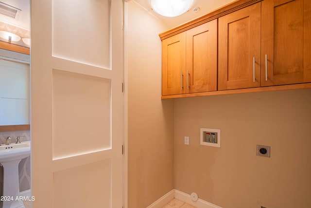 laundry area featuring washer hookup, cabinets, sink, and hookup for an electric dryer