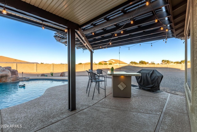 view of patio / terrace featuring a bar, a fenced in pool, and grilling area