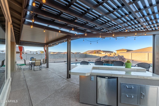 view of patio with a pergola, an outdoor bar, and exterior kitchen