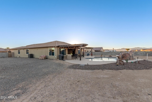 rear view of property with a patio, a fenced in pool, and cooling unit