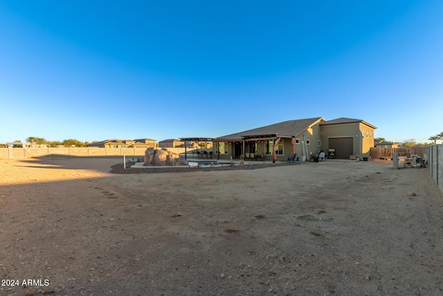 back of property featuring a fenced in pool and a garage