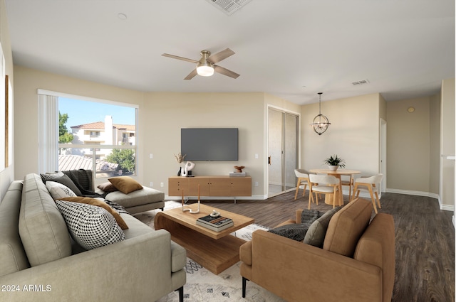 living room with ceiling fan with notable chandelier and hardwood / wood-style flooring