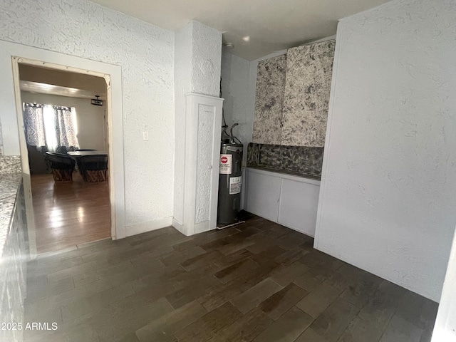 hallway with water heater and dark hardwood / wood-style flooring