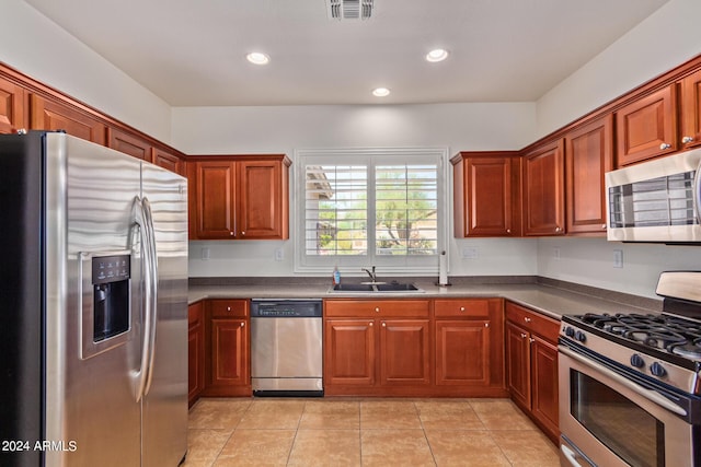 kitchen with stainless steel appliances, sink, and light tile patterned floors