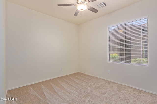 empty room with ceiling fan and light carpet