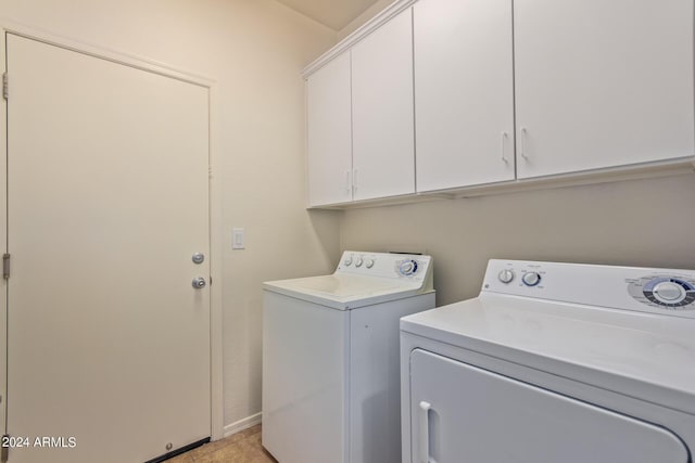 laundry room with separate washer and dryer and cabinets