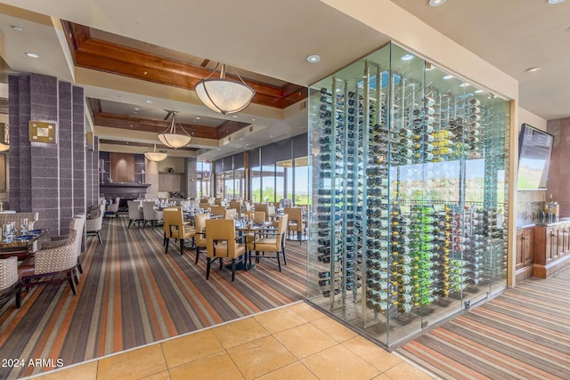 wine cellar with tile patterned flooring and a raised ceiling