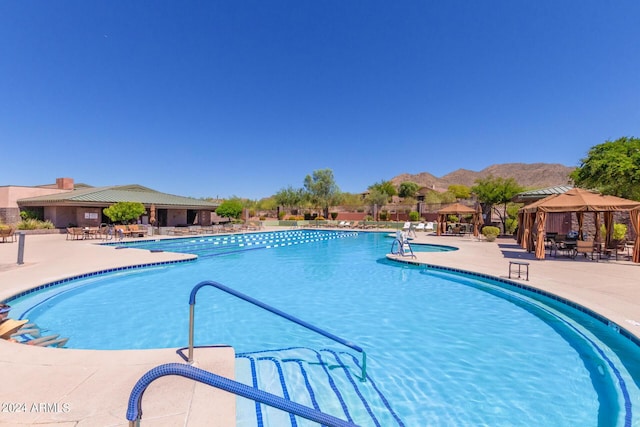 view of pool featuring a gazebo, a mountain view, and a patio