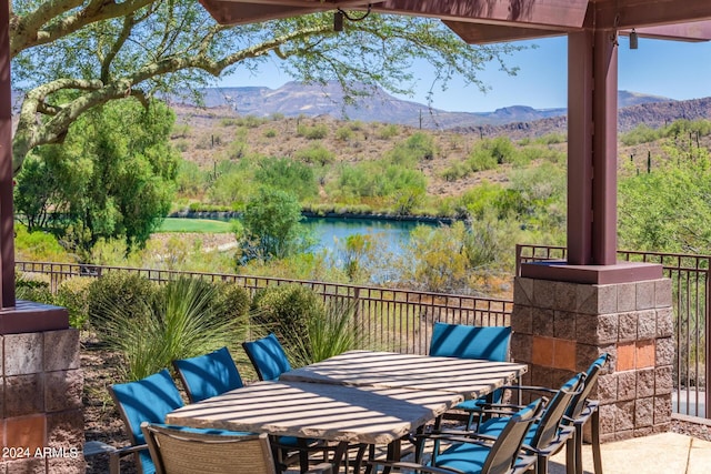 view of patio / terrace featuring a water and mountain view