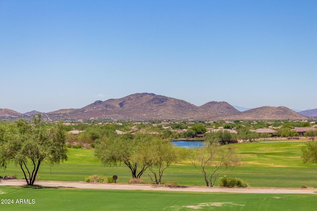 view of home's community with a water and mountain view and a lawn