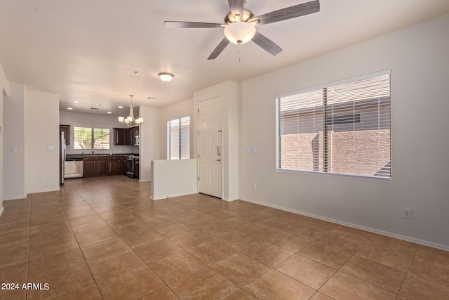 unfurnished living room with tile patterned flooring and ceiling fan with notable chandelier