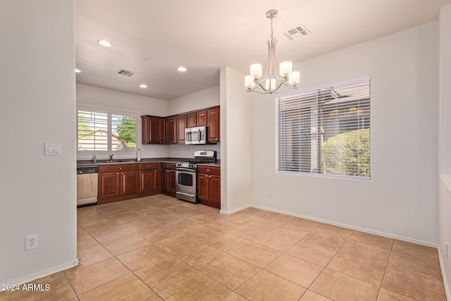 kitchen featuring pendant lighting, sink, light tile patterned floors, an inviting chandelier, and stainless steel appliances