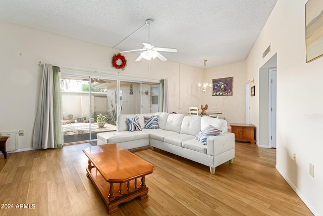 living room featuring light hardwood / wood-style floors, a textured ceiling, and ceiling fan with notable chandelier