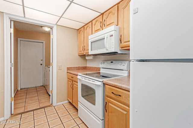 kitchen with white appliances, washer and dryer, a drop ceiling, light tile patterned floors, and light brown cabinets