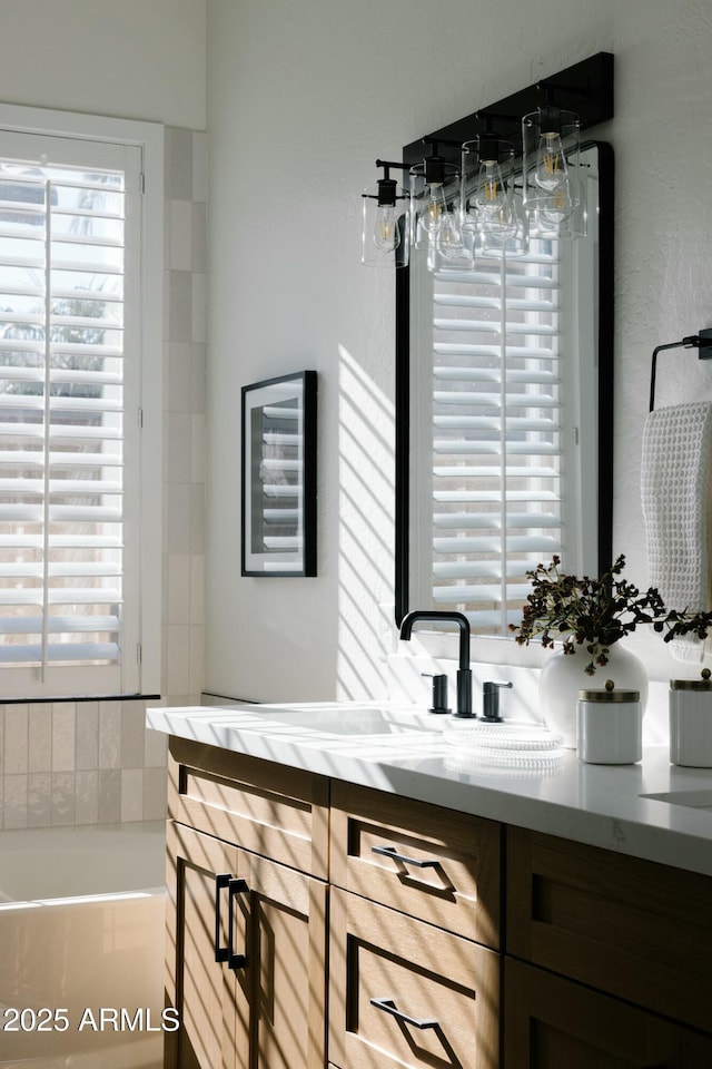 bathroom with a tub and vanity