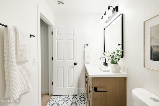 bathroom featuring toilet, tile patterned flooring, and vanity