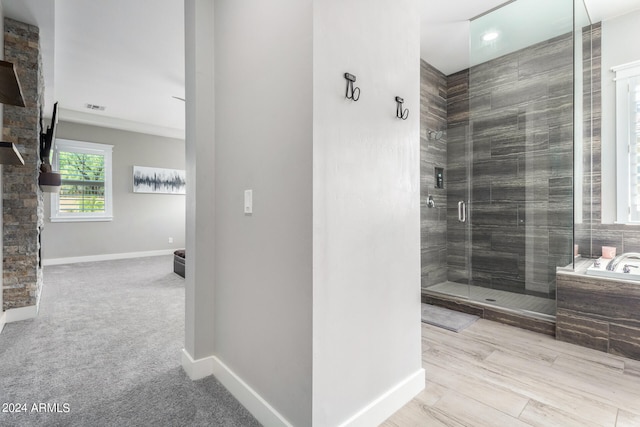 bathroom with hardwood / wood-style flooring and independent shower and bath