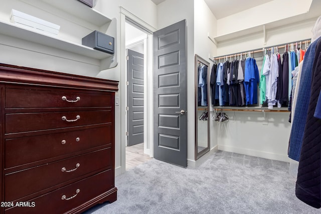 walk in closet with light carpet