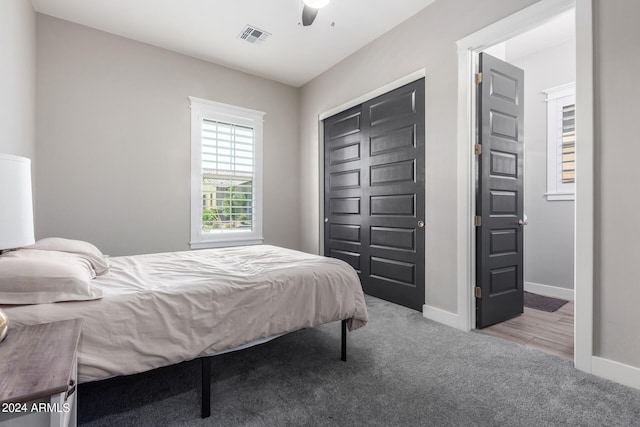 carpeted bedroom featuring ceiling fan and a closet