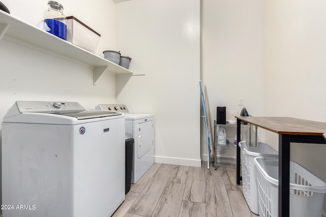 laundry area with light wood-type flooring and washer and clothes dryer