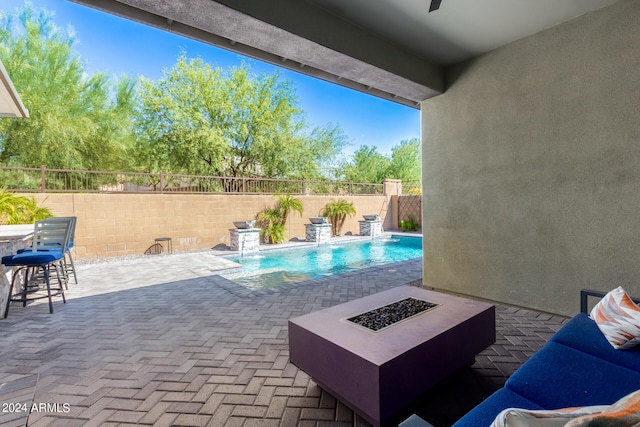 view of swimming pool with pool water feature, a patio area, and an outdoor fire pit