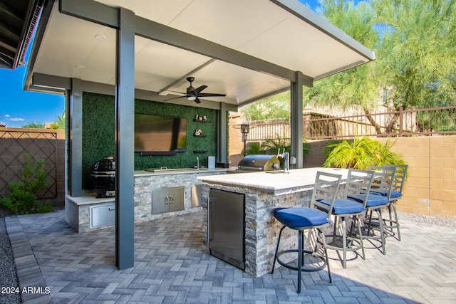 view of patio / terrace featuring exterior kitchen, ceiling fan, area for grilling, and exterior bar