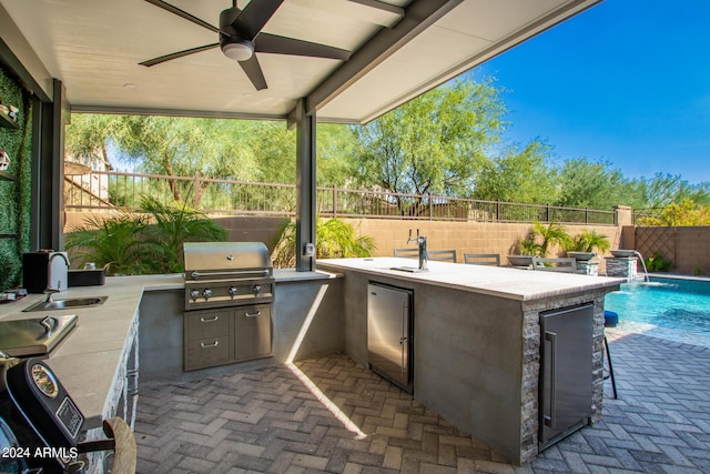 view of patio / terrace featuring a fenced in pool, area for grilling, ceiling fan, and pool water feature