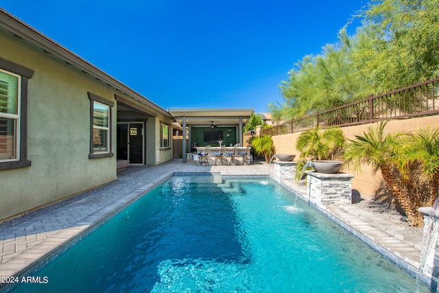 view of pool with pool water feature, ceiling fan, and a patio area