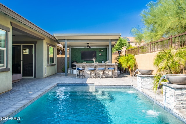 view of pool with pool water feature, a patio, and ceiling fan