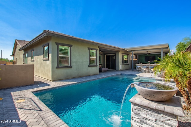 view of swimming pool with a patio area, ceiling fan, and pool water feature