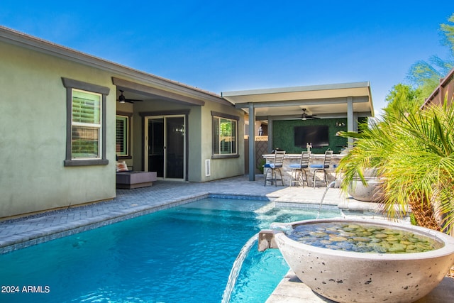 view of swimming pool featuring pool water feature, ceiling fan, and a patio