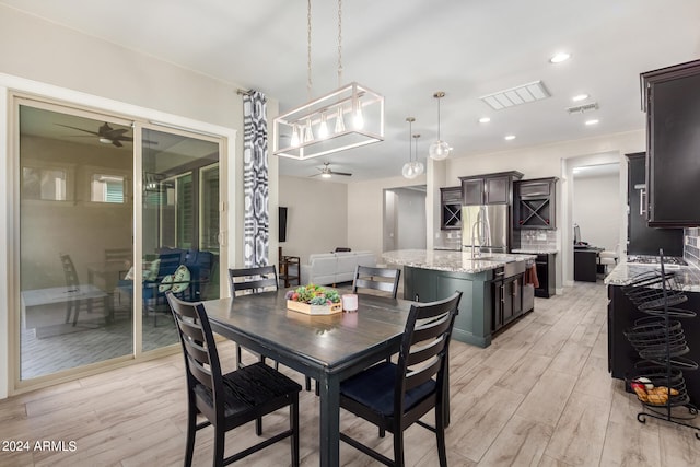 dining area with ceiling fan, sink, and light hardwood / wood-style floors