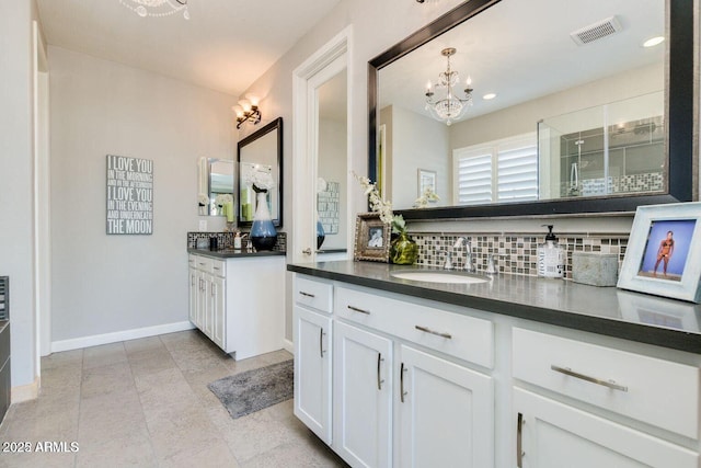 1952 W Yellowstone Way, Chandler, AZ 85248 - bathroom featuring tasteful backsplash, a chandelier, two vanities, a shower stall, and baseboards