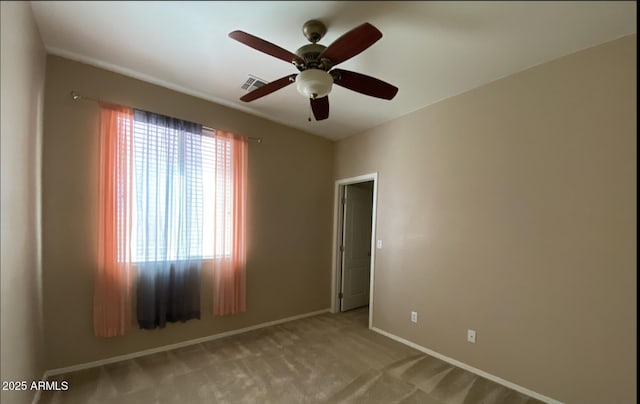 unfurnished room with light colored carpet and ceiling fan