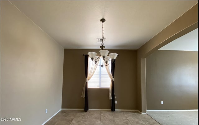 spare room featuring a notable chandelier