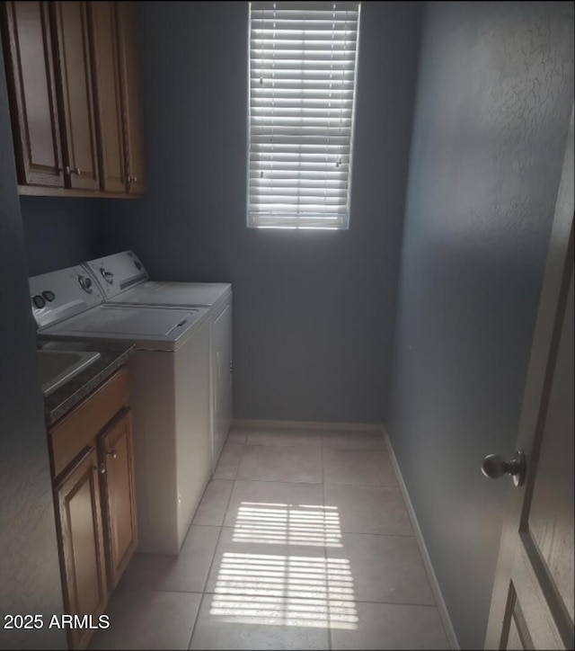 laundry area featuring cabinets, washer and dryer, and light tile patterned floors