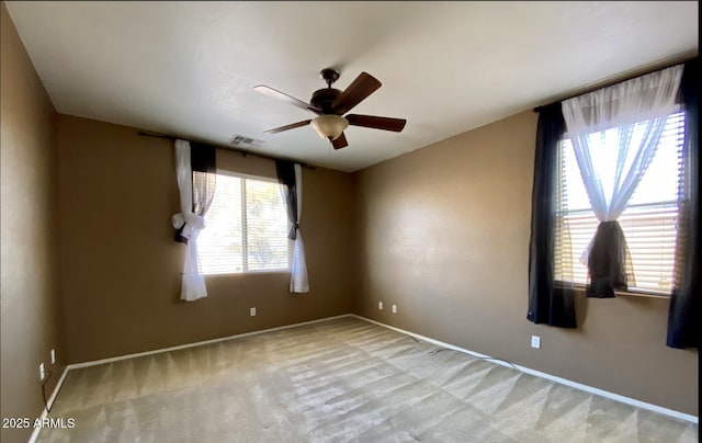 carpeted empty room featuring plenty of natural light and ceiling fan