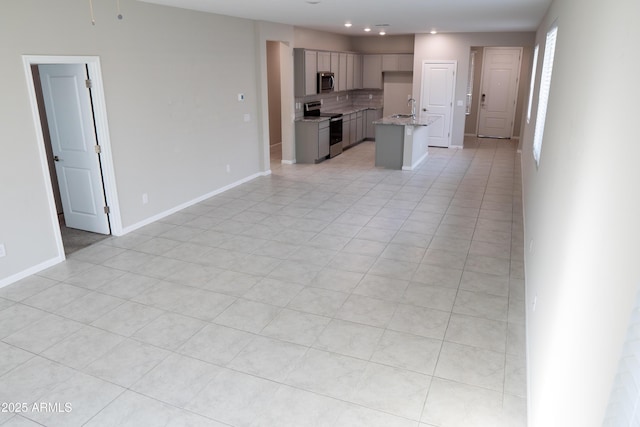 unfurnished living room featuring sink and light tile patterned floors