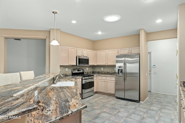 kitchen featuring stainless steel appliances, decorative backsplash, dark stone counters, pendant lighting, and sink